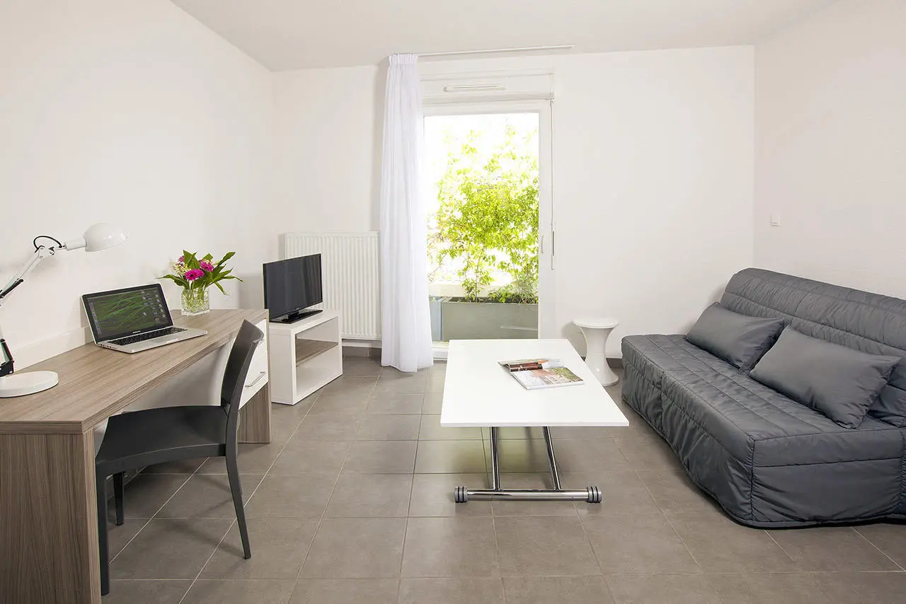 Studio Les Estudines Port Marianne à Montpellier — lit, coin salon et bureau